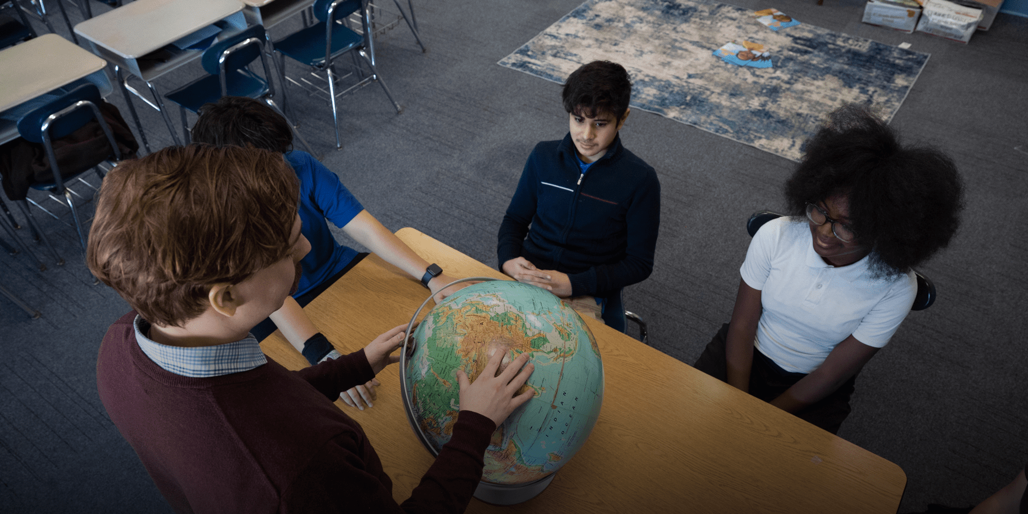Students looking at globe